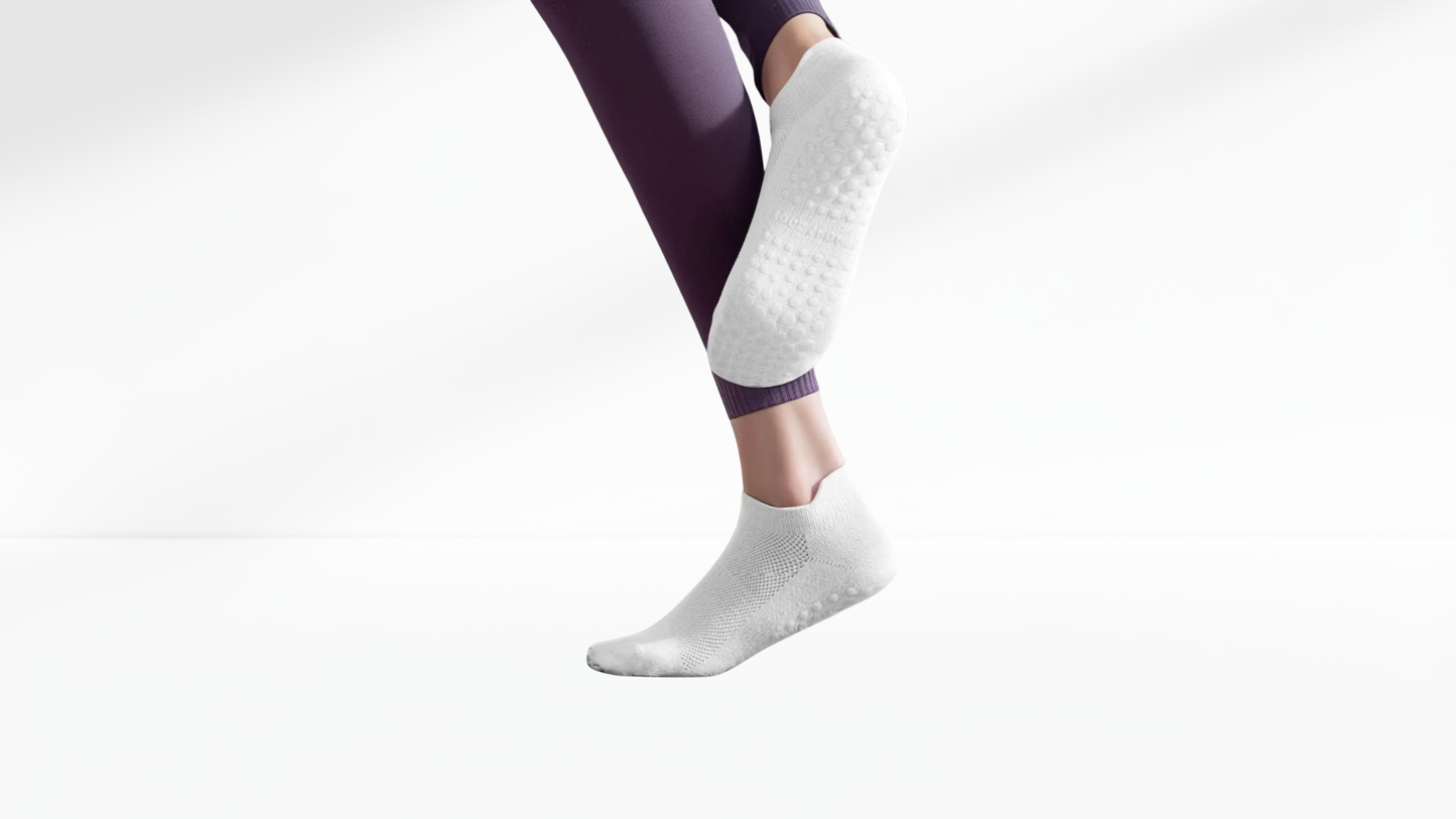 White grip socks worn with purple leggings on a light gray background