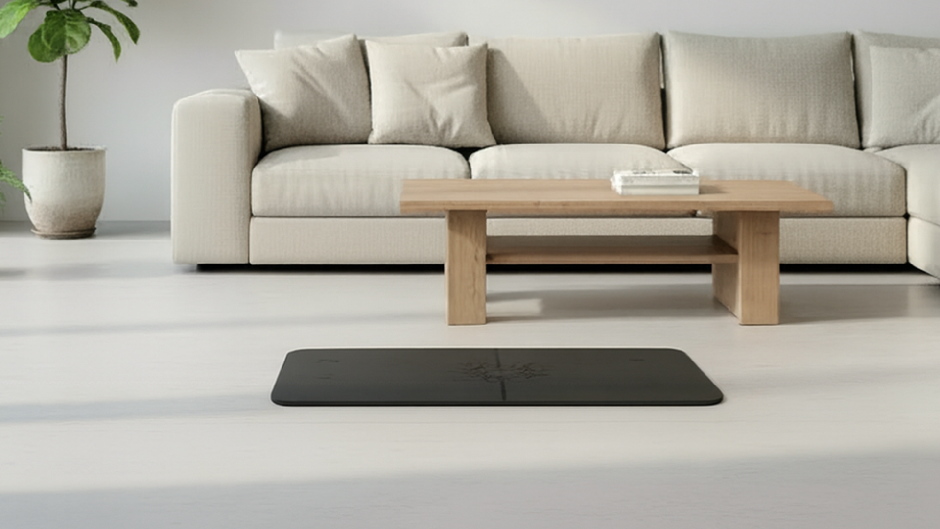 Black flat support yoga mat placed in a modern living room setting on a light floor, minimalist aesthetic.
