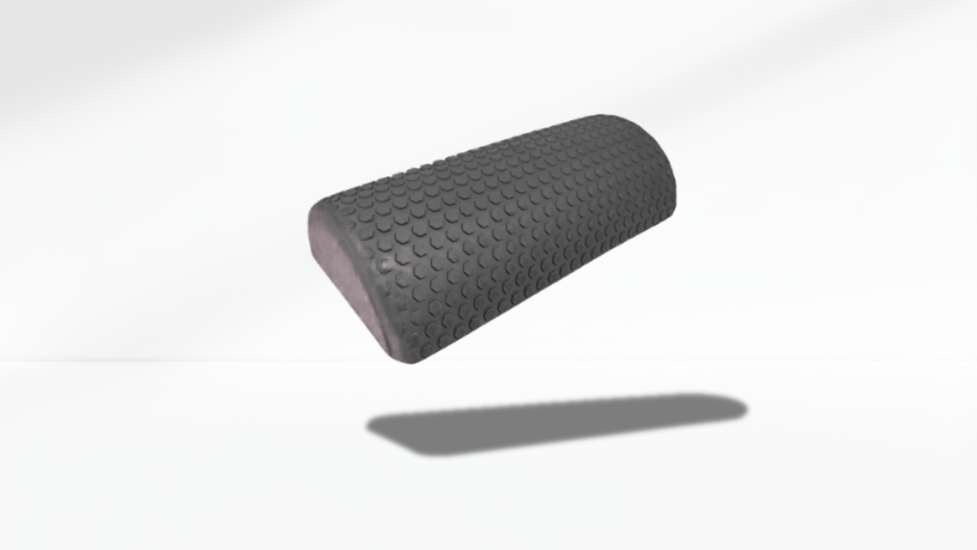 black textured half foam roller shown in an angled floating view with soft shadow, highlighting its curved shape and massage surface.