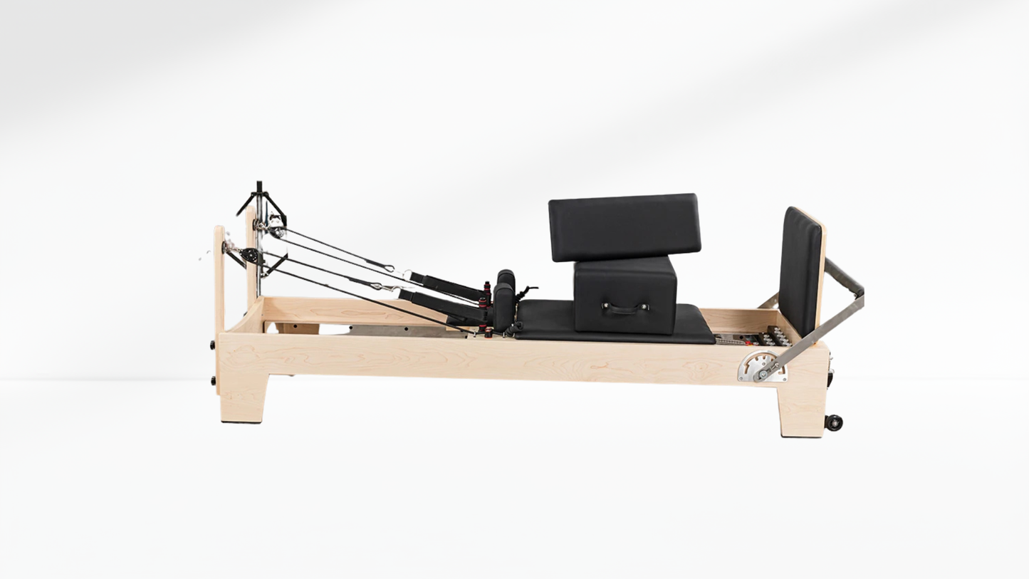 white maple Pilates reformer machine on a white background