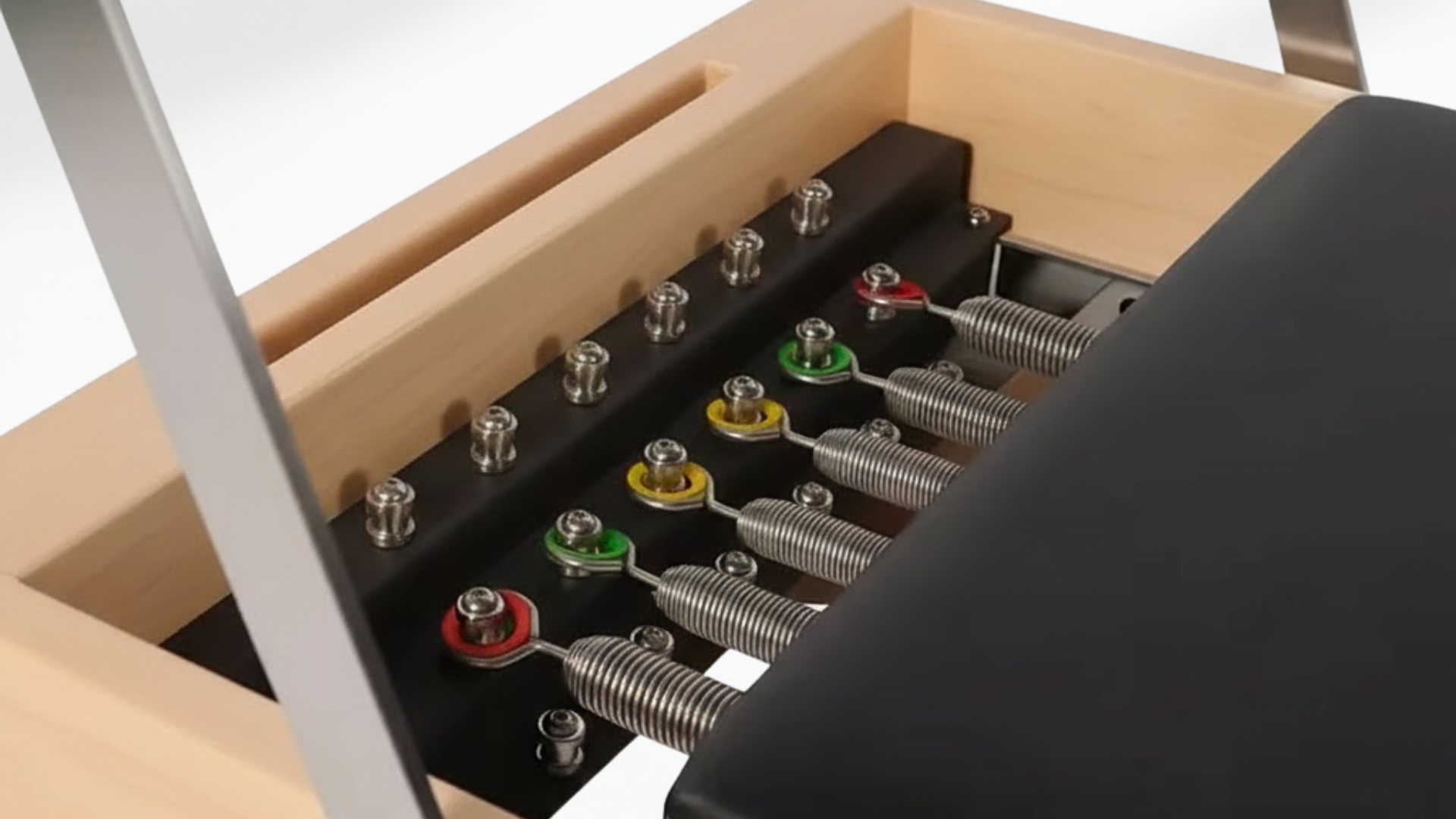 white maple pilates reformer  of a mechanical device with springs and metal components on a light background
