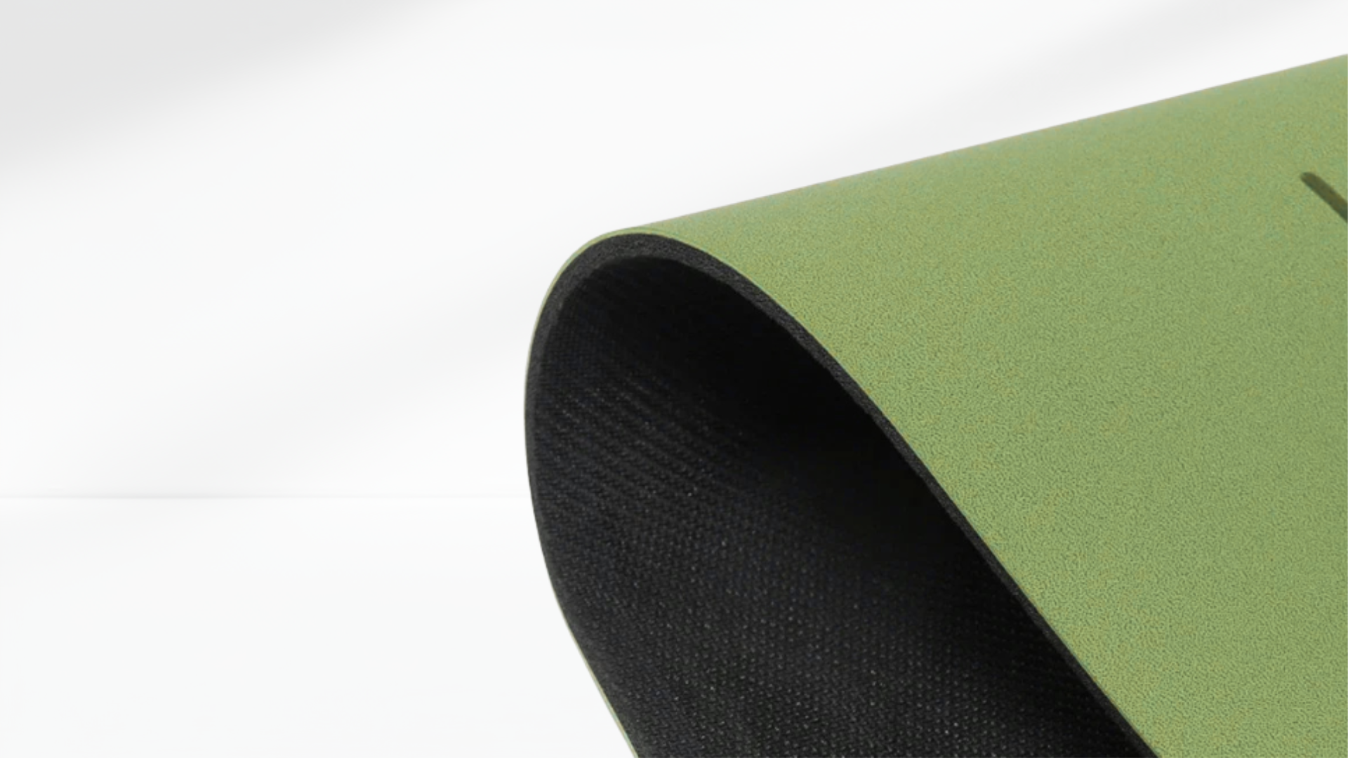Close-up side view of a green yoga support mat showing its curved edge and textured anti-slip surface.