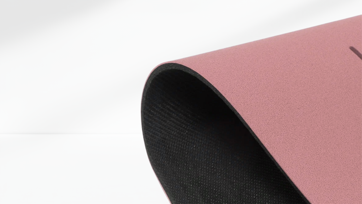 Close-up side view of a pink yoga support mat showing its curved edge and textured anti-slip surface.