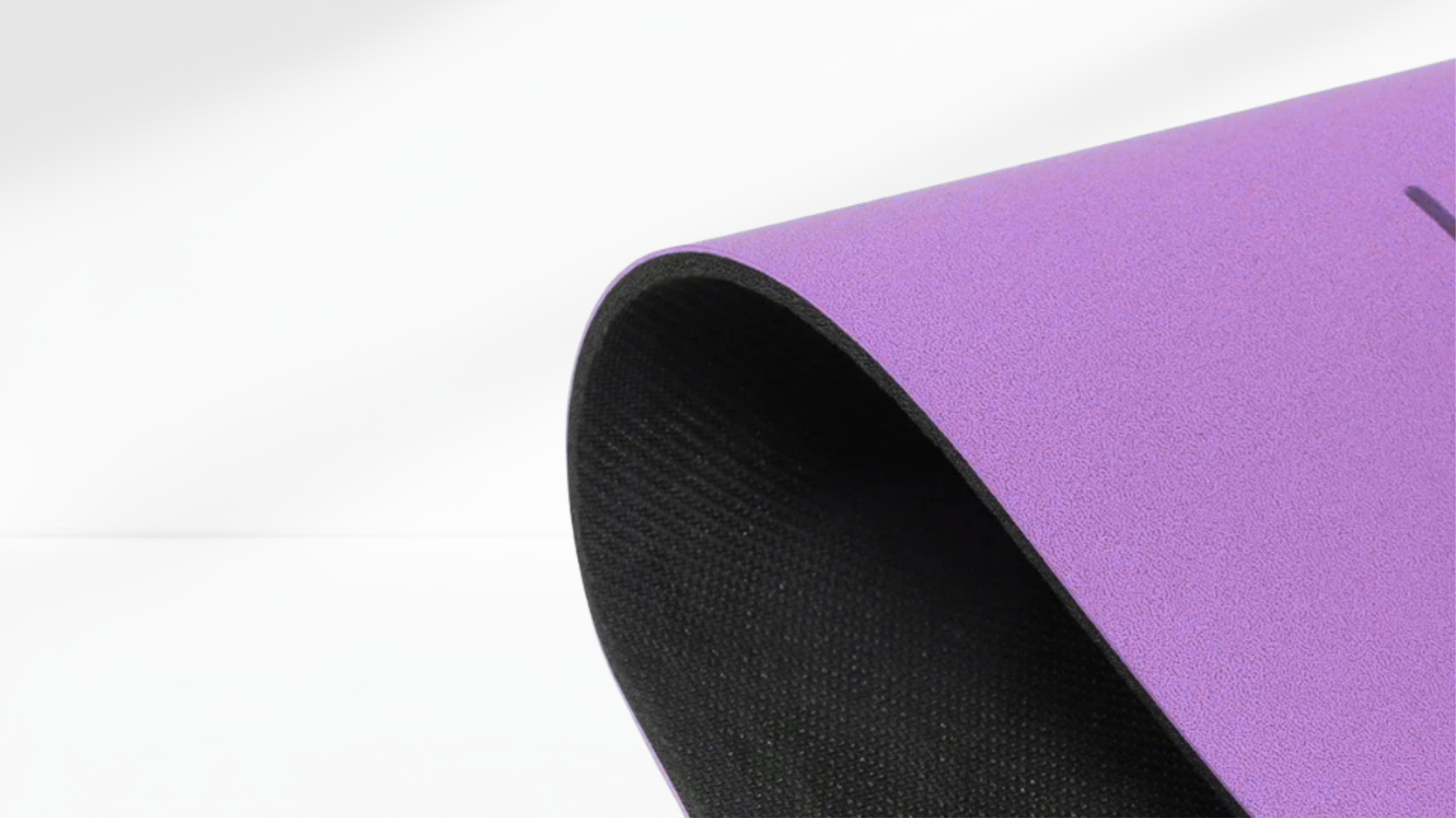 Close-up side view of a purple yoga support mat showing its curved edge and textured anti-slip surface.